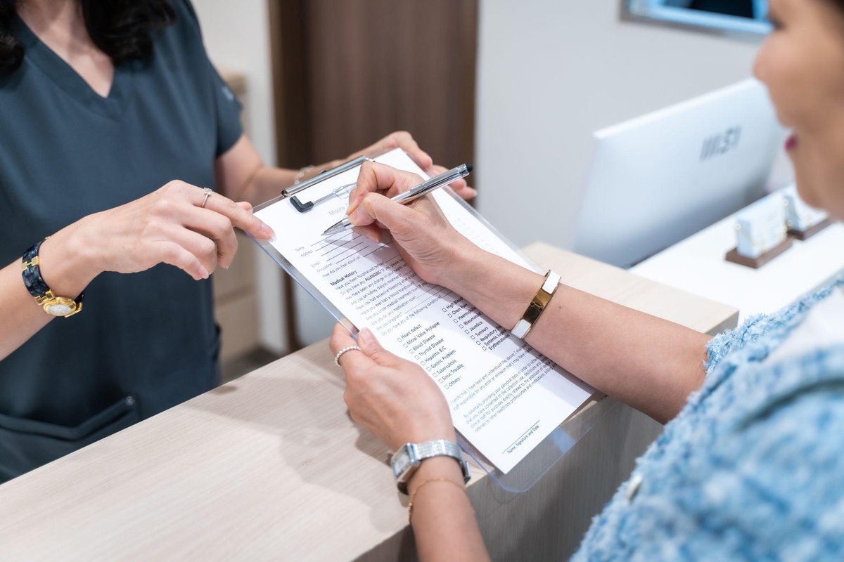 Clinic coordinator explaining Medisave claim eligibility for dental implant surgery in Singapore