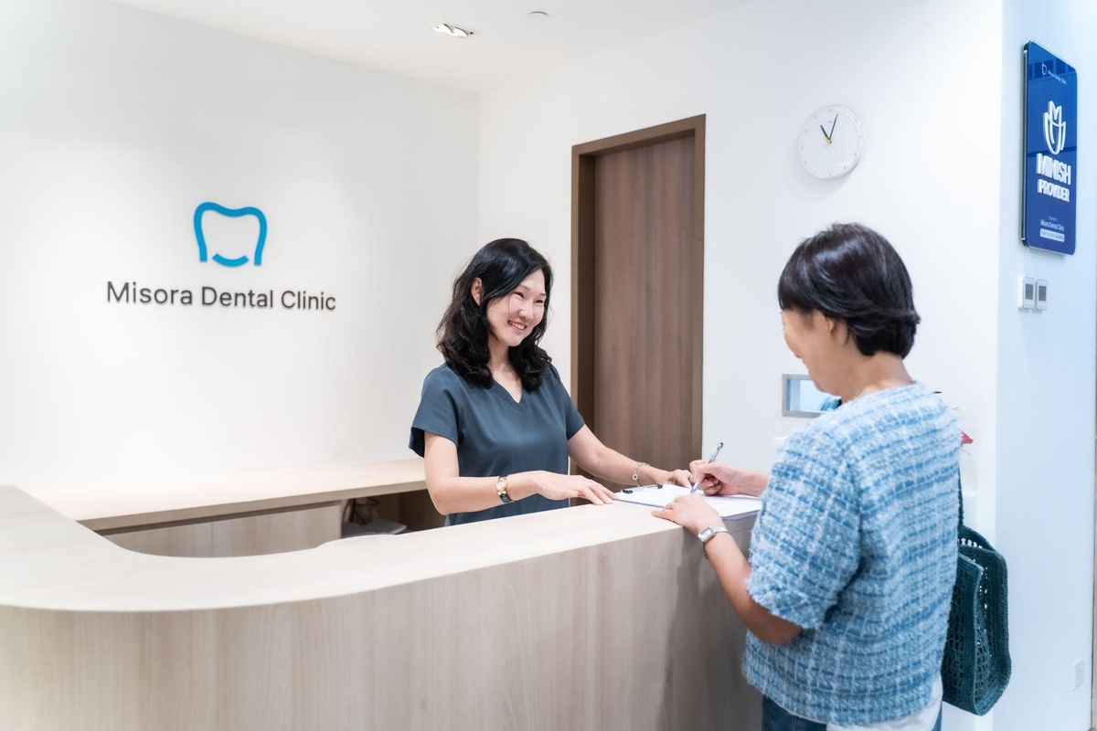 Coordinator explaining MediSave coverage for dental implant surgery at a Singapore dental clinic