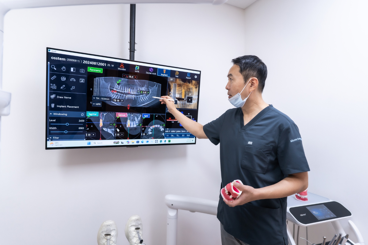 Dentist explaining dental implant surgery and recovery using a 3D scan in Singapore